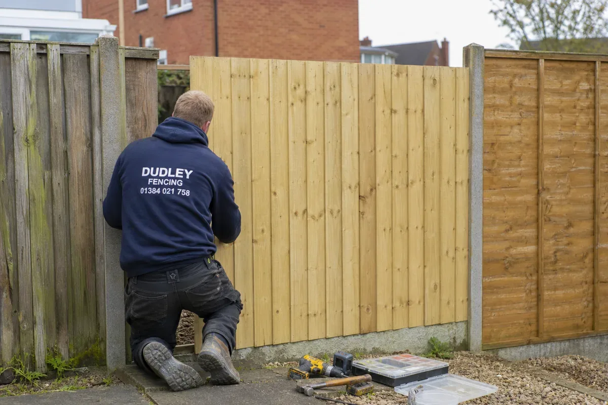 Damaged garden fence being repaired in Dudley